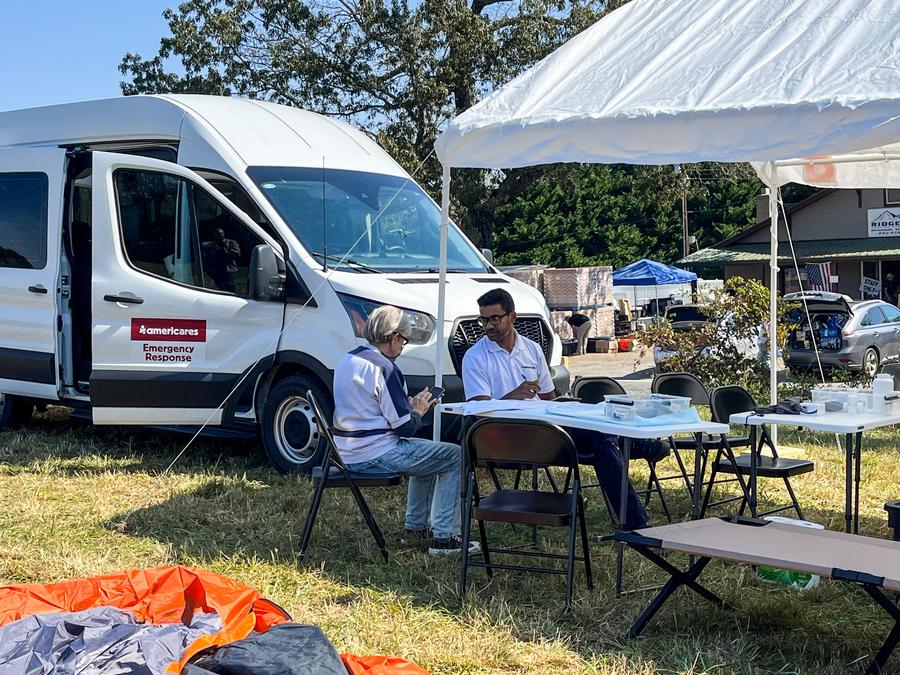 Emergency Medical Officer Prabu Selvam, MD, MHS provides medical care to a local resident outside the Americares Medical Mobile Van in Lake Lure, NC, on Saturday, Oct. 13. (Photo/Americares)