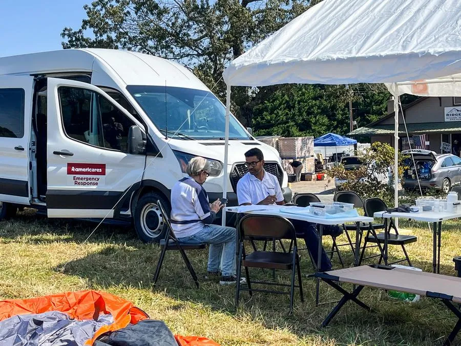 Emergency Medical Officer Prabu Selvam, MD, MHS provides medical care to a local resident outside the Americares Medical Mobile Van in Lake Lure, NC, on Saturday, Oct. 13. (Photo/Americares)