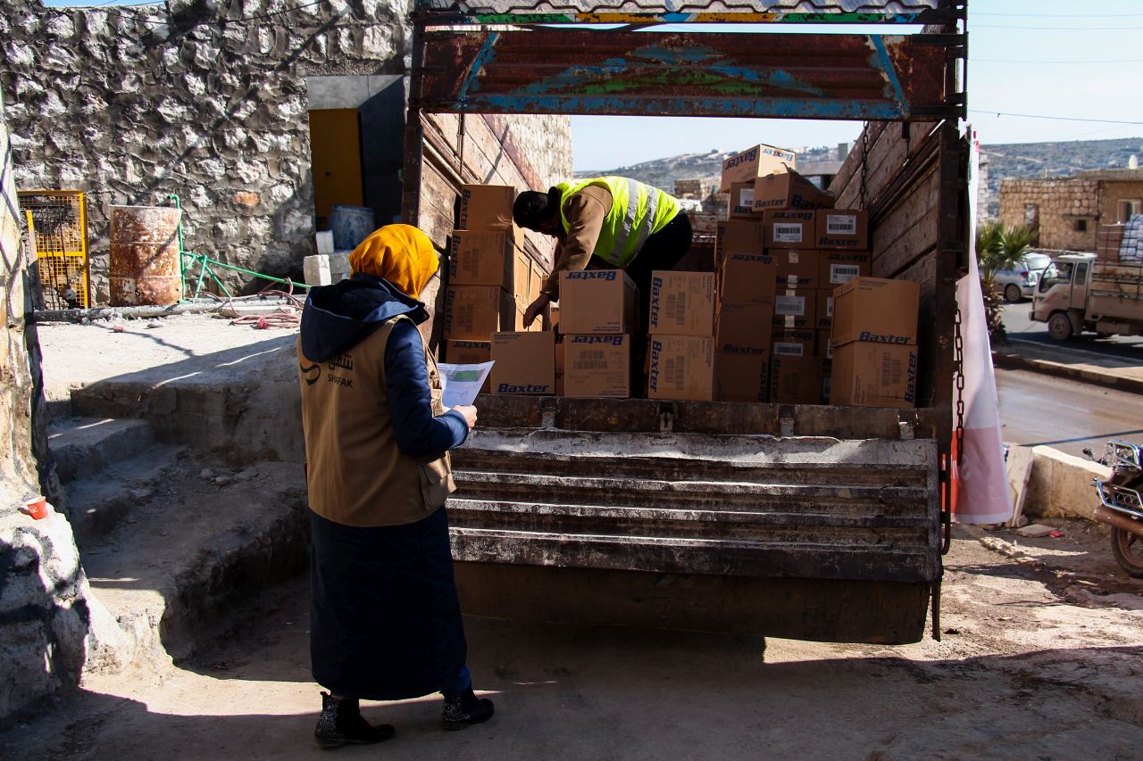 Two Shafak workers checking shipment in open truck.