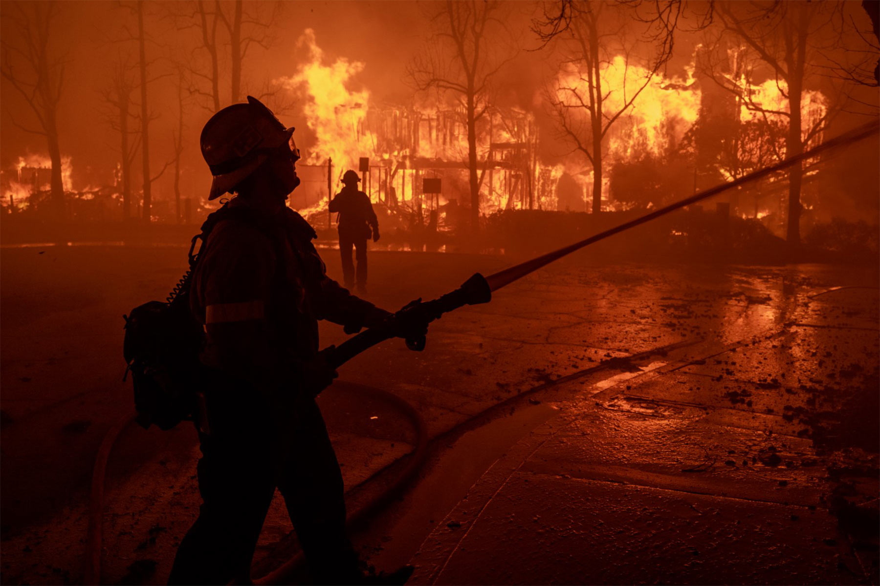 Firefighters battle the Eaton Fire in strong winds as many homes burn on January 7, 2025 in Pasadena, California. (Photo by David McNew/Getty Images)