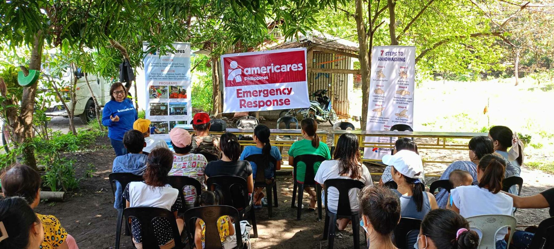 An Americares team member distributes cleaning kits and information on handwashing and hygiene to protect from infection after widespread flooding. 